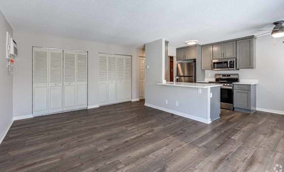 A kitchen with a refrigerator, oven, and microwave.