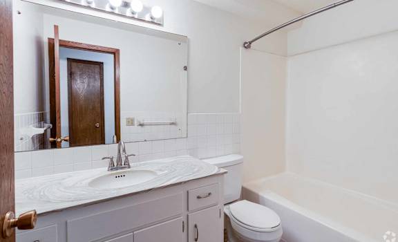A white bathroom with a sink, toilet, and bathtub.