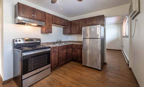 A kitchen with a stainless steel refrigerator, oven, and stove.