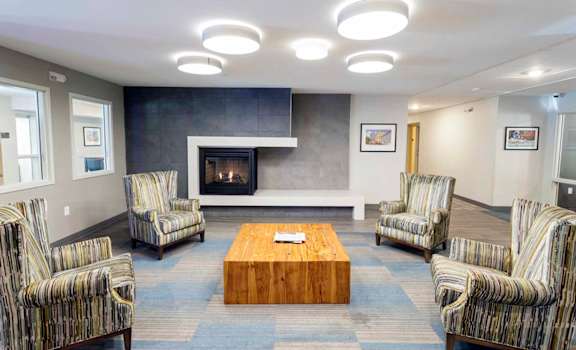 a common room with a fireplace and chairs