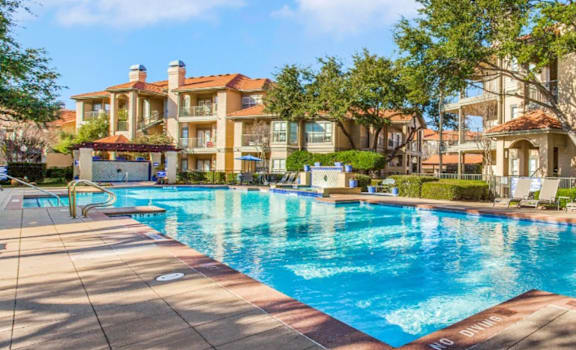 A large swimming pool in front of apartment buildings.