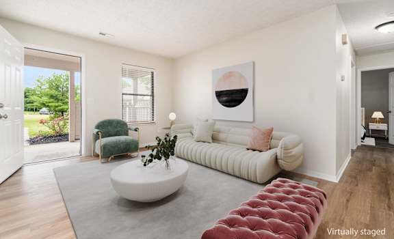 A living room with a white couch and a green chair.