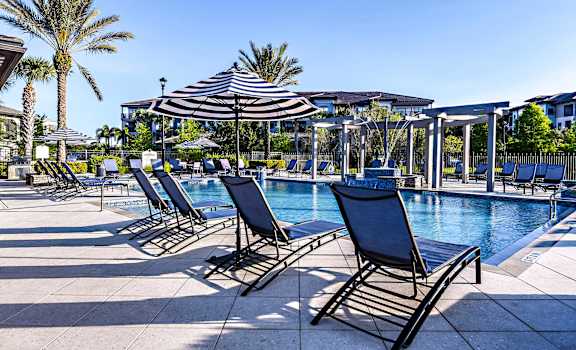 a swimming pool with lounge chairs and an umbrella
