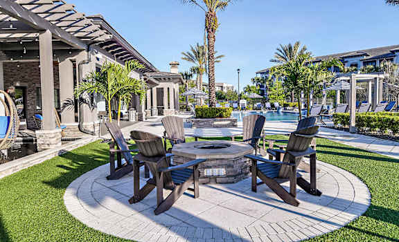 a patio with tables and chairs next to a pool