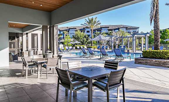 a patio with tables and chairs and a swimming pool