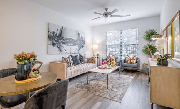 a living room with a ceiling fan and expansive windows at The Core apartments