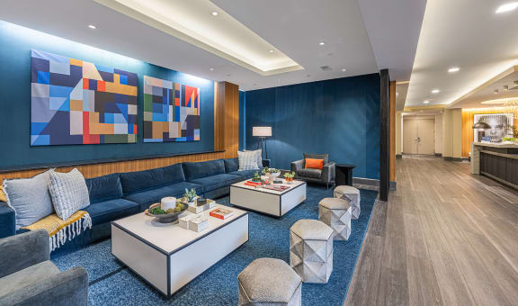 a living room with a blue wall and blue couches and tables