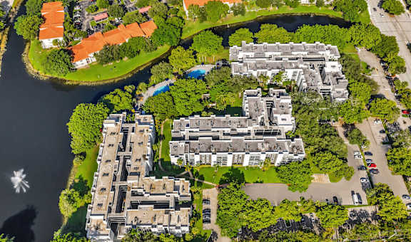 A bird's eye view of a residential area with houses, trees, and a river.