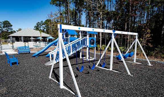A playground with a blue slide and white structure.