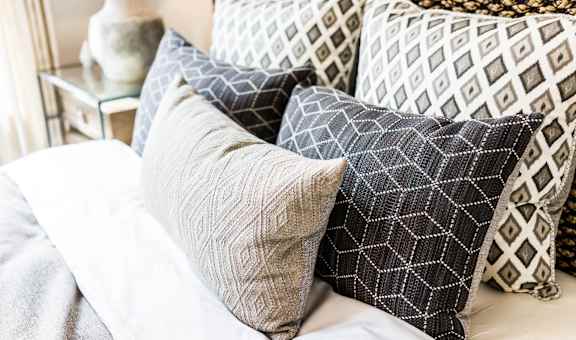 a pile of pillows on top of a bed at The Palms, Charleston, SC
