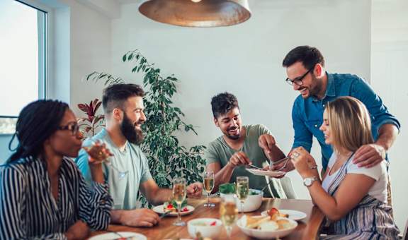a group of people sitting around a table eating food at The Palms, Charleston