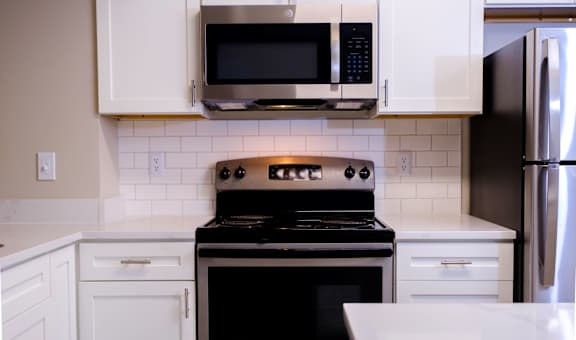 a kitchen with white cabinets and a black stove top oven