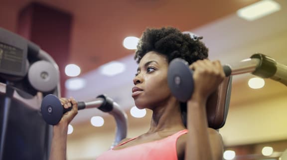 Woman using exercise machine in fitness center
