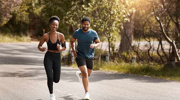 a man and a woman running down a road