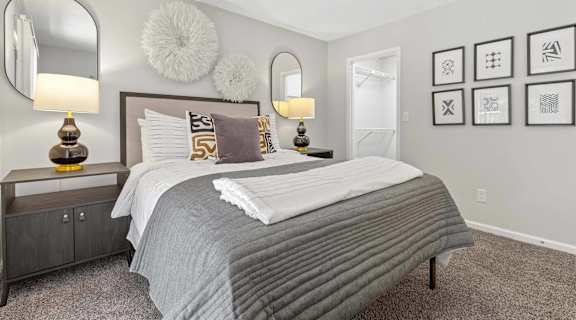 A bedroom with a large bed and two lamps.