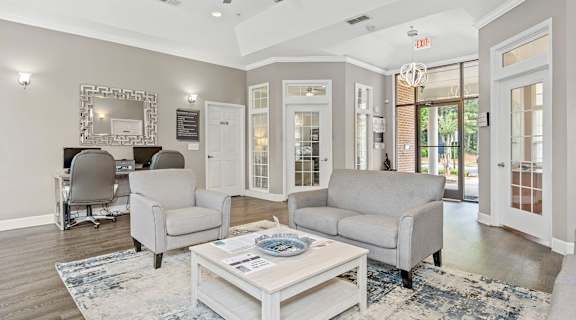A living room with a white ceiling fan and grey couches.