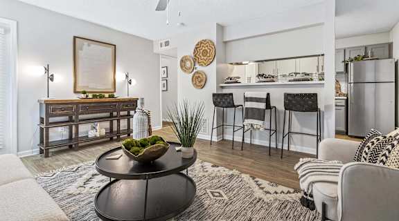 A living room with a black coffee table and a framed picture on the wall.