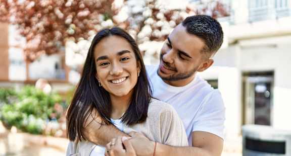 Man and Woman Smiling while Hugging Each Other Outside