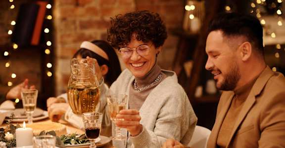 a group of people sitting at a table with food and drinks