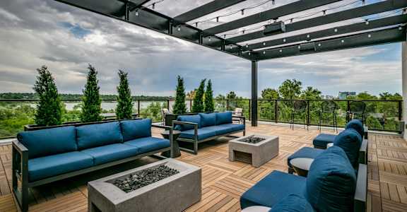a roof top patio with blue couches and tables