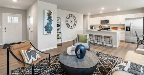 A modern living room with a large clock on the wall.