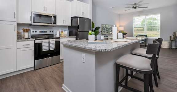 A kitchen with a granite countertop and a ceiling fan.