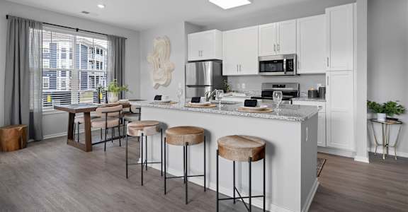 A modern kitchen with white cabinets and a large island.