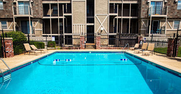 a large pool with an apartment building in the background