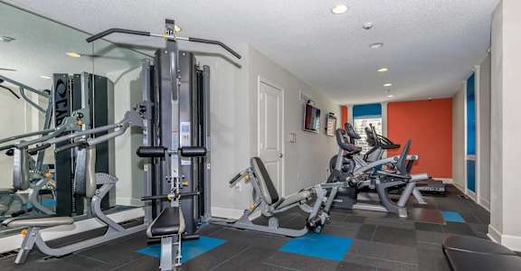 A gym with a variety of equipment including a leg press machine.