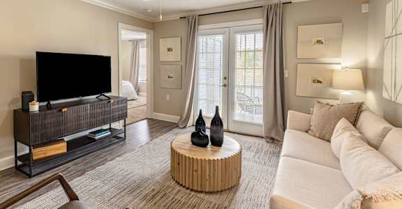 A living room with a flat screen TV and a white couch.