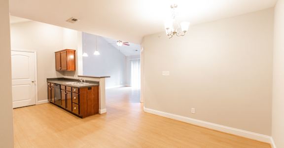 A kitchen with a wooden island and a chandelier.