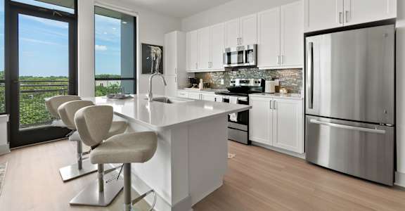 a kitchen with white cabinetry and stainless steel appliances at Tapestry West in Richmond, VA 23230