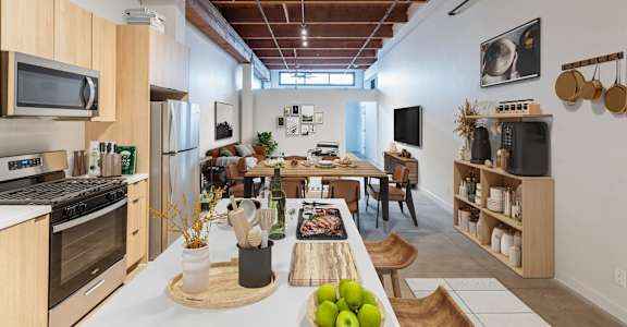 A kitchen with a wooden table and chairs, a refrigerator, a stove, a microwave, and a TV.