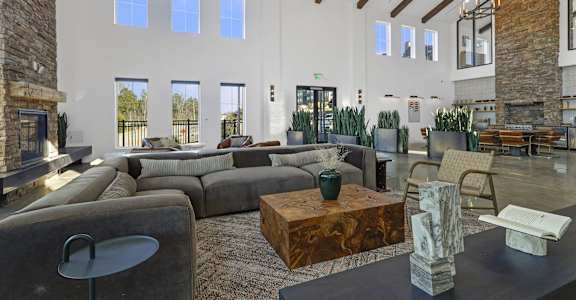 A large, modern living room with a stone fireplace and a variety of seating options.
