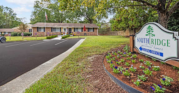 A sign for Southridge Nursing Home is in the foreground of a parking lot.