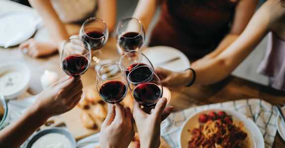 people holding up wine glasses at a table at Aura Stonebridge, Richmond