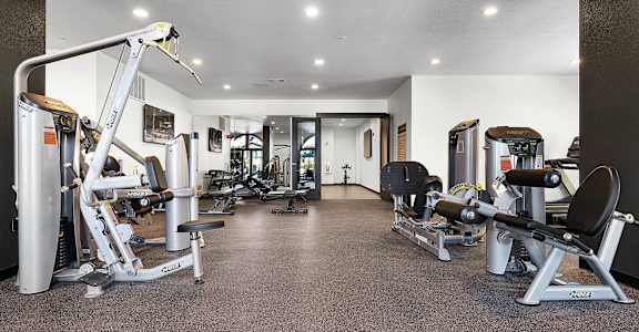A gym with a variety of equipment including a leg press machine.