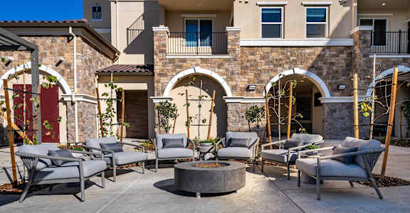 A patio with chairs and a table in front of a house.