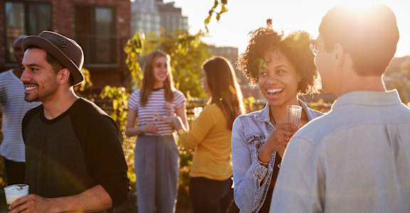a group of people talking and laughing at a party