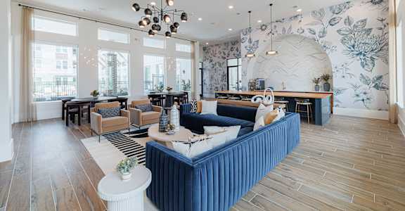 A living room with a blue sofa and wooden floors.