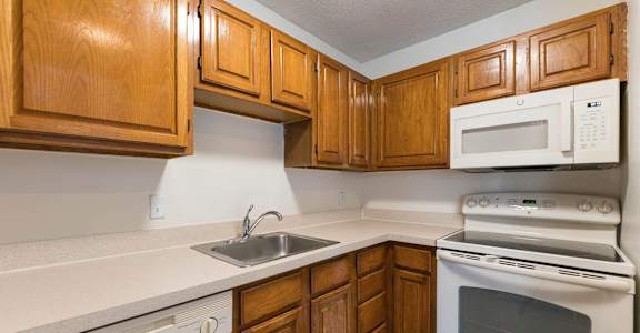 A kitchen with wooden cabinets and white appliances.