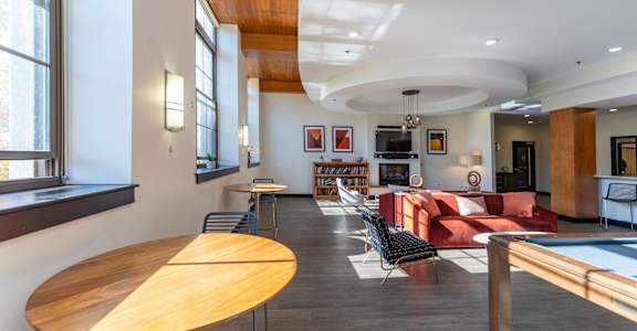 a living room with a red couch and a pool table