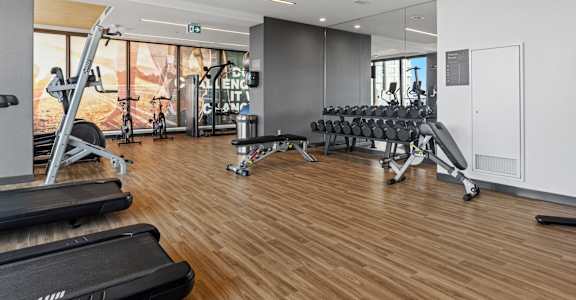 A gym with treadmills, weights, and exercise equipment.