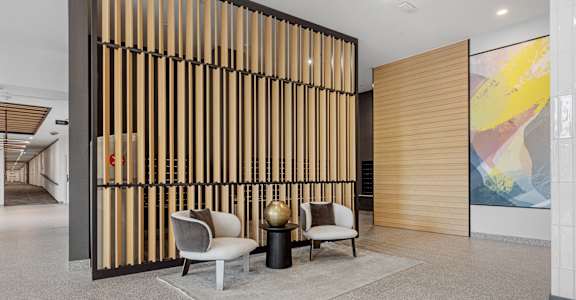 A room with a wooden partition and two chairs.