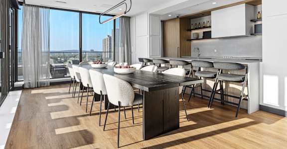 A modern kitchen with a long table and chairs.