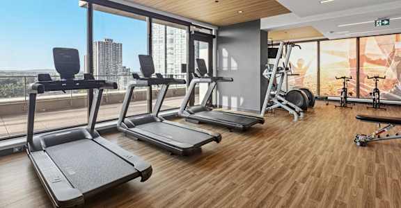 A gym with treadmills, weights, and exercise equipment.