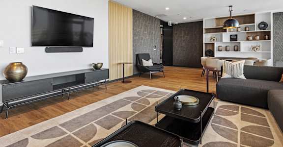 A modern living room with a flat screen TV mounted on the wall.