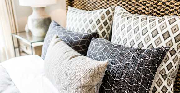 a pile of pillows on top of a bed
