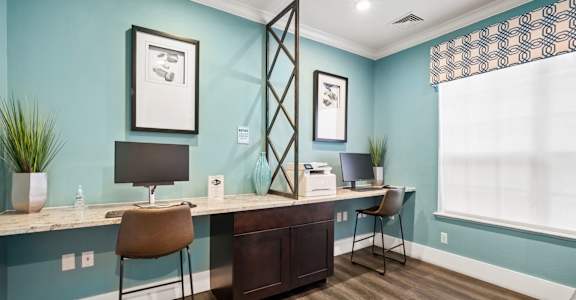 Counter with computers and stools at The Grand Reserve at Tampa Palms Apartments, Tampa, 33647