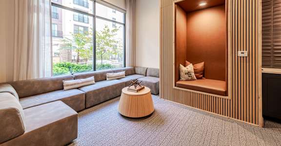 A modern living sitting nook with a large window and a wooden accent wall